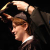 Lois Bosch places a hood on a Master of Social Work student during the commencement ceremony.